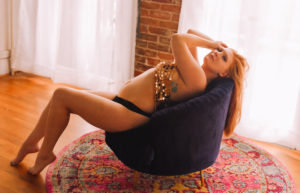 Roseville boudoir photography with redhead in blue velvet chair and gold bodychain bra