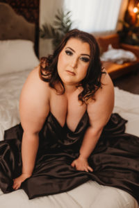 Sacramento boudoir photography with plus size woman in black satin sheet for implied nude art