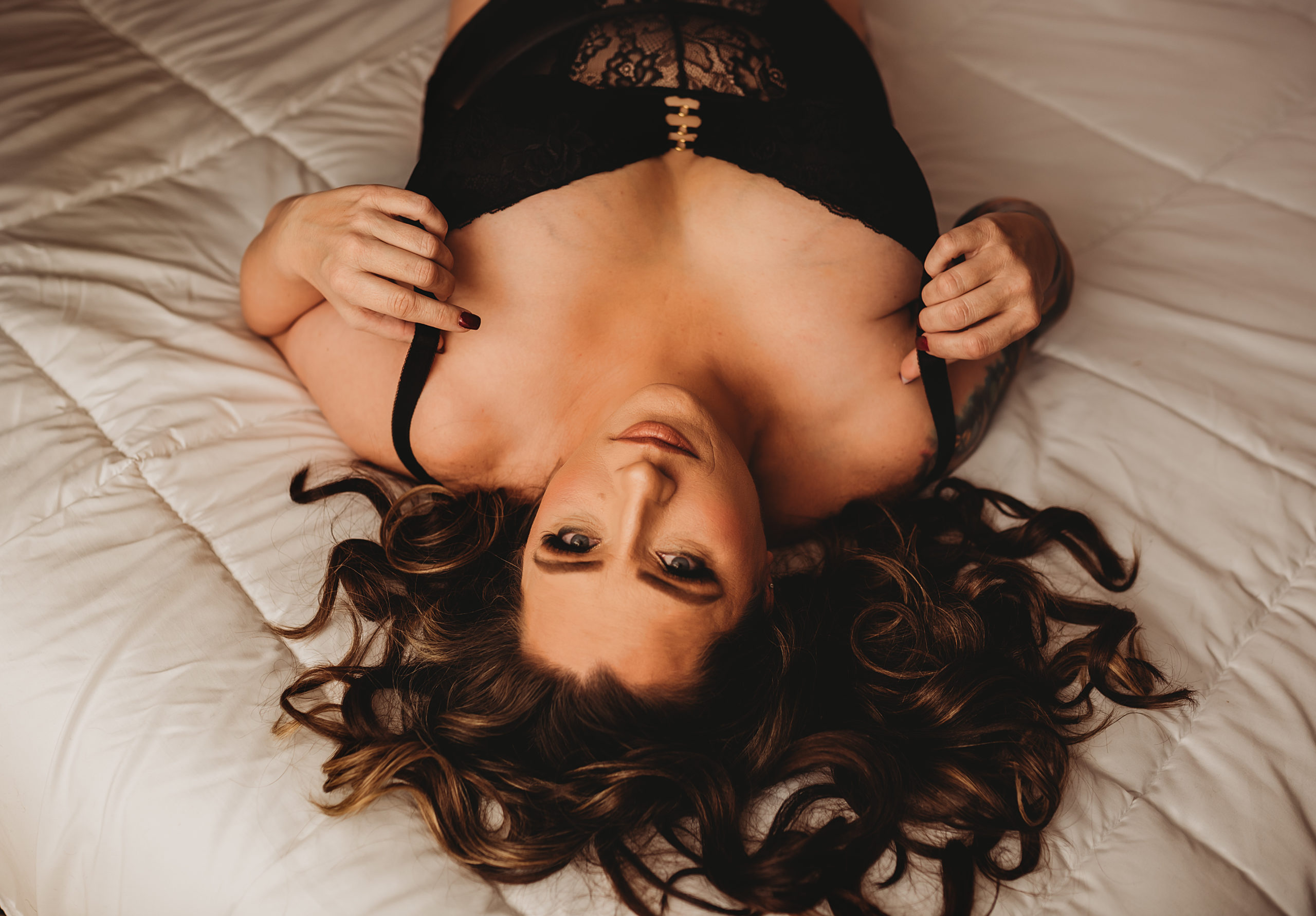 Folsom boudoir photography tattooed woman on bed in black lace. Folsom boudoir photographer, boudoir photos, boudoir photo session,