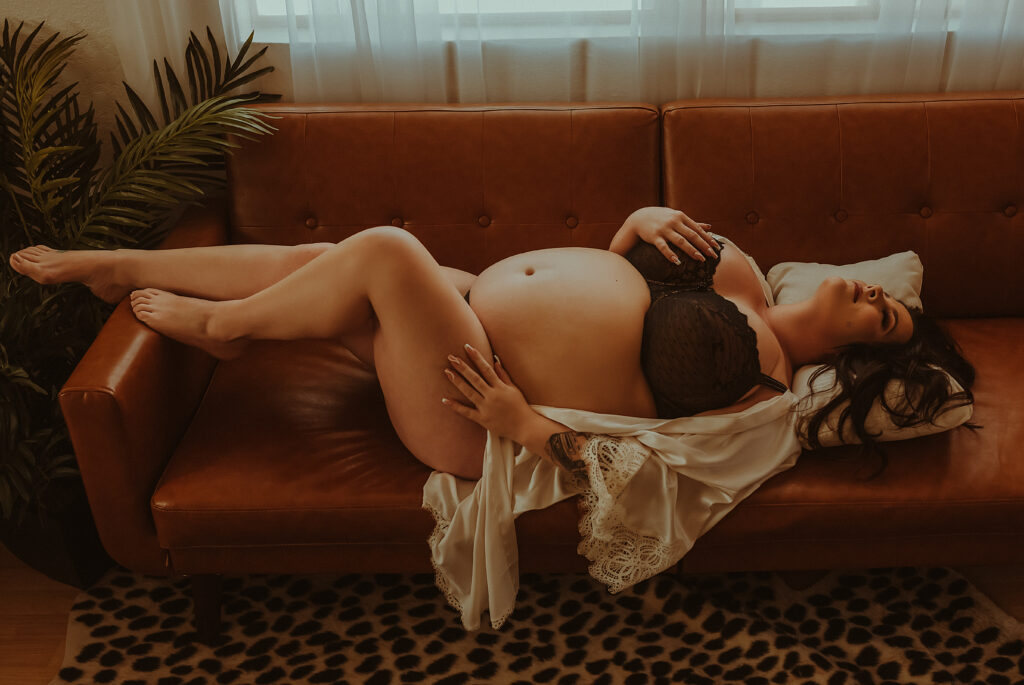 In this breathtaking maternity boudoir photograph by Limitless Boudoir, a pregnant mother exudes grace and sensuality in a stunning black lace lingerie set and a delicate white lace kimono. This photo shoot was captured in Sacramento CA, making it an ideal option for those seeking maternity and pregnancy boudoir photo shoots in Northern California. This photograph showcases the mother's beautiful curves and the swell of her belly in a tasteful and artistic manner, creating a memorable keepsake for her and her family. This maternity boudoir photograph is perfect for celebrating the magic of pregnancy and showcasing the mother's strength and sensuality in a way that is both empowering and beautiful.