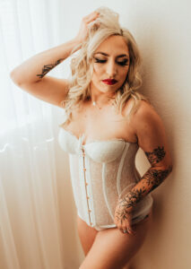 In this Bridal Boudoir photograph shot in Sacramento with Limitless Boudoir, a beautiful bride wears a delicate white lace garter belt, showcasing a rhinestone wedding ring and diamond. The ring symbolizes the bride's impending nuptials and commitment to her groom, while the garter belt adds a touch of femininity and sensuality. This photo is the perfect gift for a groom on his wedding day, capturing the bride's beauty and sensuality in a way that is intimate and personal. The image serves as a testament to the bride's love and affection, and symbolizes the bond that the couple shares. This Bridal Boudoir photograph is an ideal way to celebrate the love and passion that two people share on their special day.