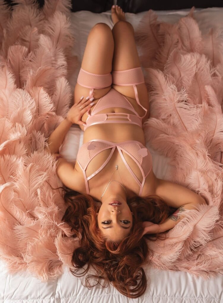 In this breathtaking artistic boudoir photograph captured by Limitless Boudoir in El Dorado Hills, California, a woman is featured wearing magnificent 6-feet tall pink feathered angel wings. This photo embodies the perfect setting for women in the Sacramento area looking for artistic, romantic, and luxurious boudoir photography. The woman's delicate pink lingerie, combined with the magnificent wings and angelic setting, create an elegant and dreamy atmosphere. The soft lighting in the background provides a warm and relaxing ambiance, while the woman's emotional expression conveys feelings of calm and tranquility. The photograph exudes a sense of femininity, sophistication, and beauty, simultaneously capturing the freedom and power of a confident woman. This artistic and romantic boudoir photograph provides a beautiful memory to celebrate a woman's strength, sensuality, and elegance in a truly luxurious and breathtaking setting.