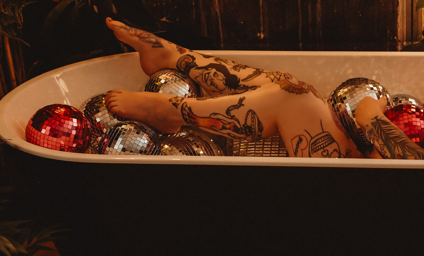 Sacramento Alternative Boudoir Photography with Tattooed woman in bathtub with disco balls
